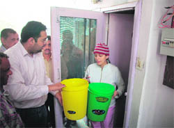 Municipal Corporation workers distributing dustbins at Ward No1 in connection with the Door-to-door garbage collection scheme launched by the MC at Shimla on Thursday. 