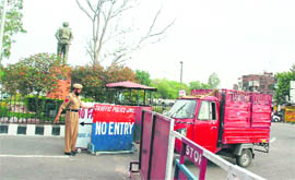 A policeman removes a board to allow entry to a load carrier in the busy Bikram Chowk in Jammu