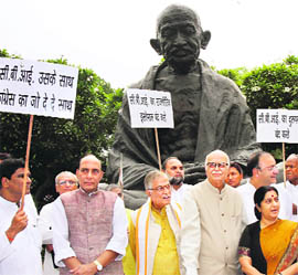 BJP parliamentary party chairman LK Advani along with his party MPs stages a protest against the alleged misuse of the CBI by the Centre in front of a statue of Mahatma Gandhi at Parliament House in New Delhi on Thursday.