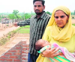 Balwant Singh and his 45-day-old son at their house near the clinker yard, posing breathing problem at Bikkon village.