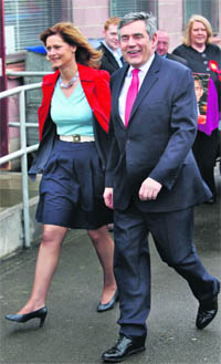 Britains Prime Minister Gordon Brown smiles as he arrives with his wife Sarah to a polling station in North Queensferry in Fife, Scotland, on Thursday.