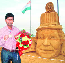 Sand artist Sudarshan Pattnaik poses with his gold medal that he won at the second Moscow World Sand Sculpture show on Thursday.