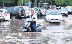 A girl stuck on a water-logged road in Sector 17, Chandigarh, on Friday.