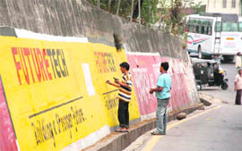 Workers of a private agency deface a wall near KC Theatre in Jammu