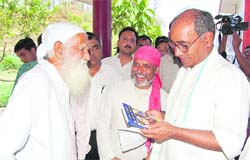 Sunder Lal Bahuguna, an eminent environmentalist, presents a book to Congress General Secretary Digvijay Singh in Dehradun on Saturday.