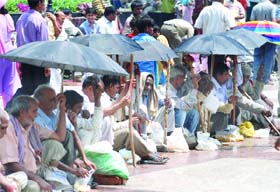 PROTECTION FROM THE SCORCHING SUN: Beggars at Hanuman Mandir, Connaught Place, in New Delhi