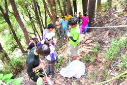 Students pick up plastic garbage on the Woodstock school campus.