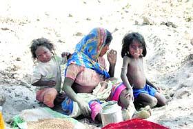 A labourer with her children at a brick-kiln at Sambli village in Karnal district