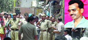 The victim (inset) and policemen outside his house in east Delhi on Monday.