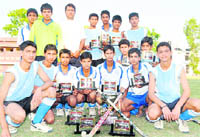 Maharana Sports College team pose with its trophy after winning the S Kandhari Memorial Hockey Tournament in Dehradun