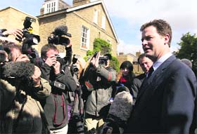 Britain's Liberal Democrats party leader Nick Clegg (right) speaks to the media as he leaves his house in London