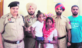 Cops hand over the child to his mother at the Haibowal police station in Ludhiana on Wednesday.