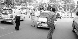 Policemen try to regulate one-way traffic on a road near the Polo Ground in Patiala