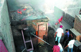 A fireman dousing the flames after fire broke out in the godown of an ice-cream shop on the Amrik Singh road in Bathinda