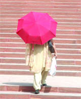A woman shields herself from the scorching sunshine near Vijay Chowk in New Delhi on Friday.