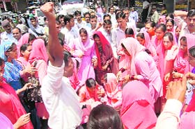 A girl-protester faints as JBT trainees raise slogans at deputy directors education office at Hamirpur