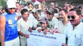 Jharkhand Cricket Associations captain Saurabh Tiwary (in blue T-shirt) and team receive the trophy and a cheque after winning the All-India Uttarakhand Gold Cup Cricket Tournament in Dehradun on Sunday.