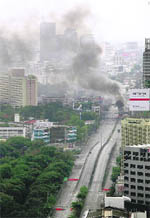 Heavy smoke billows as anti-government protesters burn tyres on a road in downtown Bangkok, Thailand,