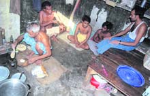 Migrant labourers prepare food in a cramped room.