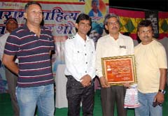Comedian Khayali Saharan (second from left) honours writer and poet Krishan Kumar during a show in village Peelibanga. 