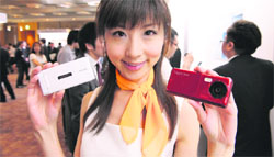 A model displays KDDI's brand, AU's new 2010 summer models of moble handsets in Tokyo on Monday. KDDI introduced 13 water-proof models in the Japanese market. 