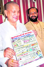 Union Minister of State Harish Rawat shows Kumbh newspaper clippings dipicting Kumbh-related corruption in Haridwar on Tuesday