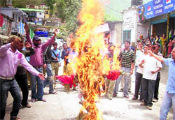 Members of the Rawanlta-Jaunpur community burn an effigy of the state government