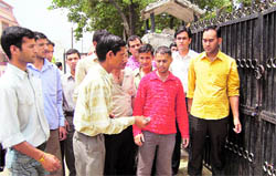 Employees of the Unani and Ayurvedic Directorate lock the gates of their office in Dehradun on Tuesday