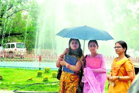With the mercury rising, students use an umbrella on the Jammu University campus on Tuesday.