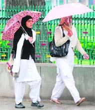 Two college girls walk in the rain in Srinagar on Tuesday