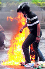 A protester walks away after setting a tyre on 