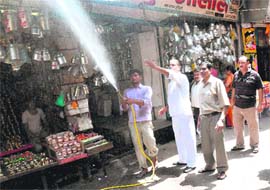 Members of the Haridwar Moti Bazar Traders Association spray insecticide.