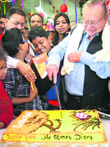 Ruskin Bond cuts a cake with children in Mussoorie on Wednesday.