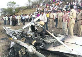  Police examine the wreckage of a trainer aircraft that crashed after hitting a high-tension wire in Ujjain on Wednesday. The pilot and woman co-pilot were killed in the incident.