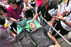 Freelance photographer Fabio Polenghi of Italy lies on a stretcher at Police Headquarter Hospital in Bangkok. He is among six persons killed in fresh violence on Wednesday. 