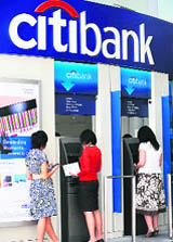 People make transactions through Citibank ATMs in Singapore