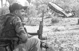 A CRPF jawan guards the remains of the bus blown up by the Naxals near Dantewada in Chhattisgarh on May 17