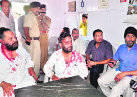 Congress general secretary Darshan Singh Jida and his brother Gurtej Singh Jida sit with Parminder Singh (extreme right), with whom they had a fight inside DPI (Punjab) office, at the police post in Sector 17, Chandigarh, on Friday.
