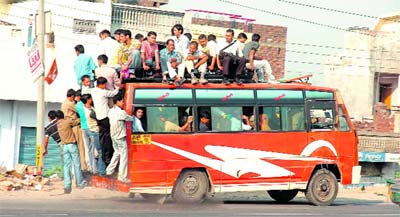 People cling to a minibus in Sarore near Vijaypur.