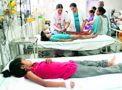 Medical staff members treat students at the Amritsar Civil Hospital on Friday after they fell ill on taking tablets distributed by teachers