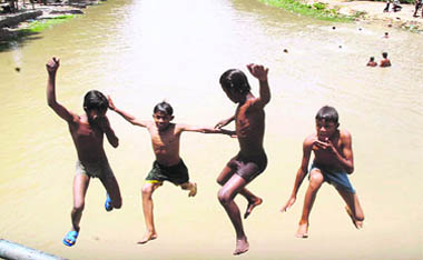 Children jump into the Sirhind Canal in Bathinda to beat the heat