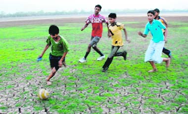 Boys play football on a dried-up portion of Sukhna Lake in Chandigarh. 