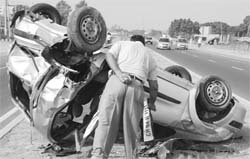 A man inspects the mangled car on the Chandigarh-Ambala highway at Dera Bassi on Monday. 