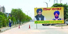 Commuters agony: A huge hoarding being put up to welcome Deputy Chief Minister Sukhbir Badal and to block a stretch on the GT Road during the foundation stone laying ceremony of BMC Chowk flyover in Jalandhar on Monday.