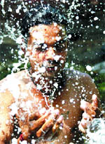 A boy splashes water on his face to beat the heat in Amritsar