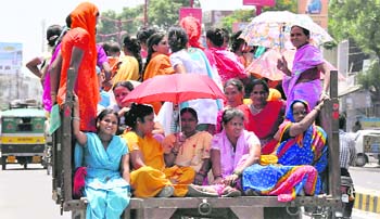 Braving the scorching heat, women activists travel in a trolley to participate in an agitation in Haridwar on Tuesday.