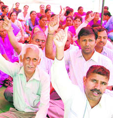 Health workers protest against non-implemetation of their demands at the civil hospital in Karnal on Tuesday.