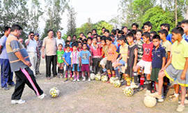 An expert gives tips to the kids participating at a camp being organised by the District Football Association in Dehradun on Wednesday