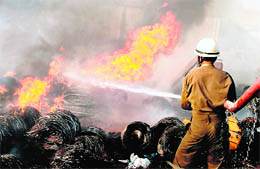A fireman tries to douse the fire that broke out in a cable factory in the industrial area at Bari Brahmana in Samba on Wednesday