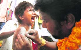 A child being pierced with needles as part of the annual worship programme.